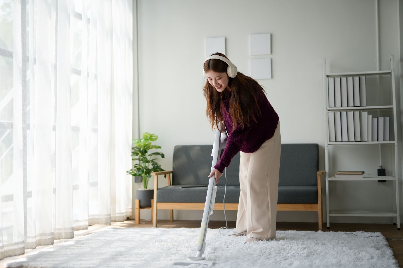 Lady listening to music while vacuuming the carpet