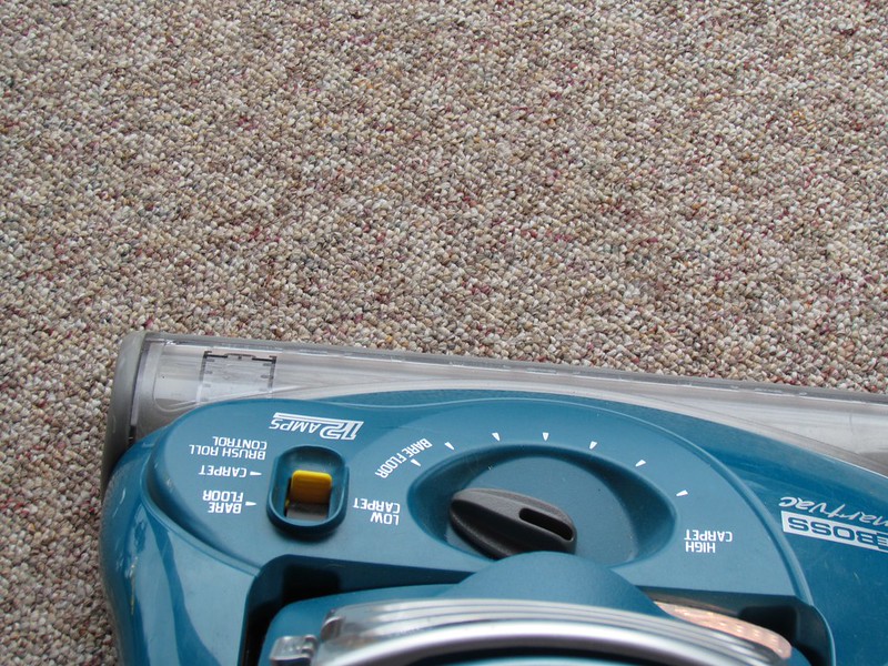 using a vacuum to clean a carpet