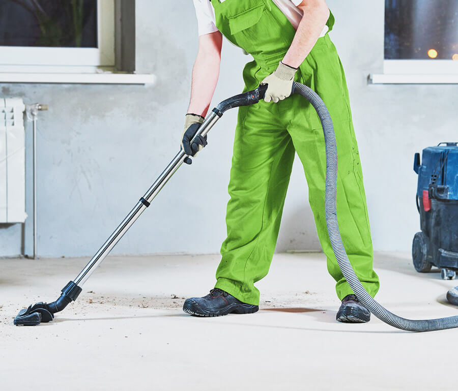 worker cleaning floor with vacuum