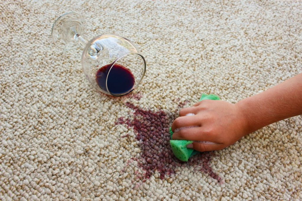 a person is cleaning the rugs after a glass of wine fell to the rug